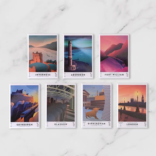Seven illustrated travel Caledonian Sleeper Fridge Magnets featuring Edinburgh, Glasgow, Birmingham, London, Aberdeen, and Inverness, arranged on a white marble surface.
